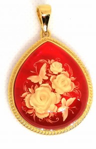 Wisiorek z czerwonym bursztynem i rzeźbieniem.